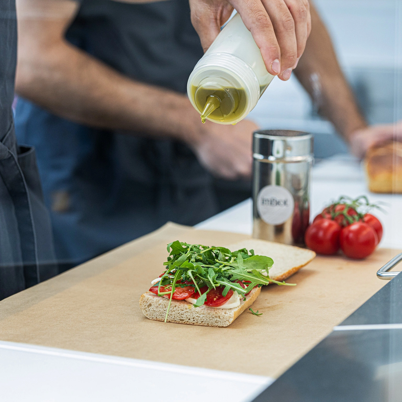 Ein Mitarbeiter richtet ein Sandwich an. Ein Mitarbeiter richtet ein Sandwich an.