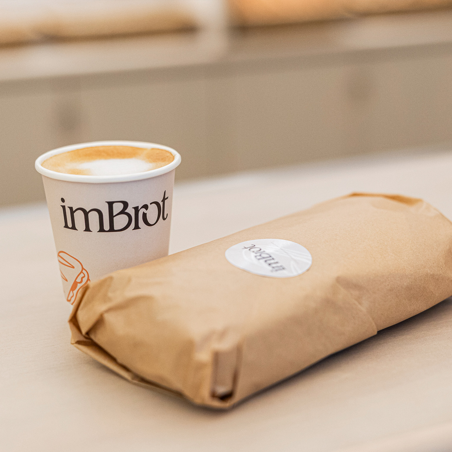 Ein verpackter imBrot Sandwich mit einem Kaffee. Ein verpackter imBrot Sandwich mit einem Kaffee.